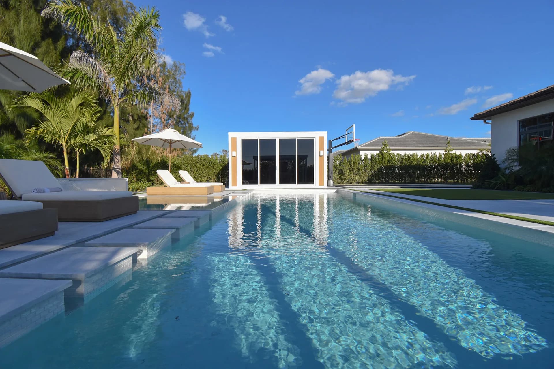 Luxapod poolside — daytime view from pool looking toward the structure