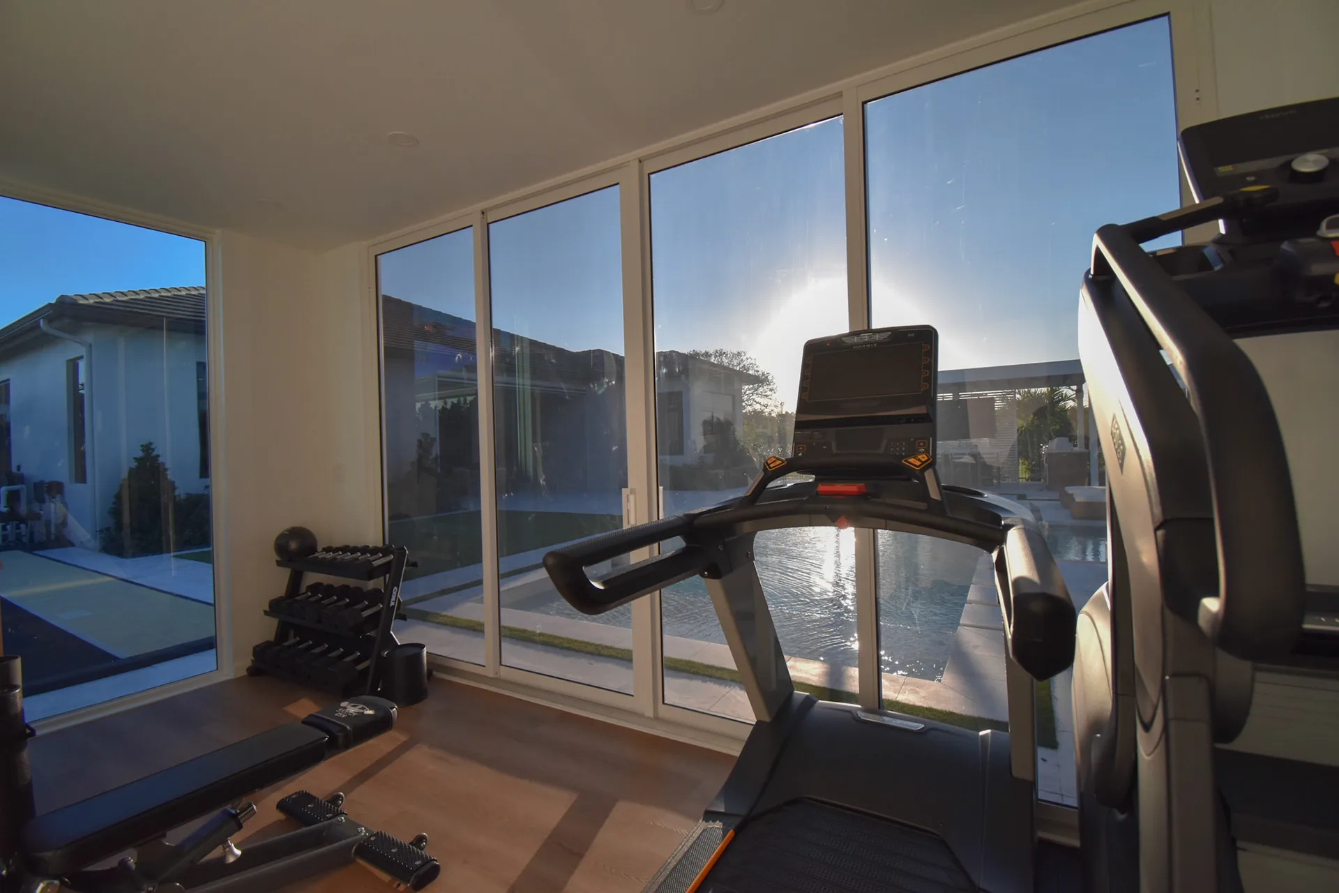 Luxapod interior — wide view of home gym with treadmill and weights