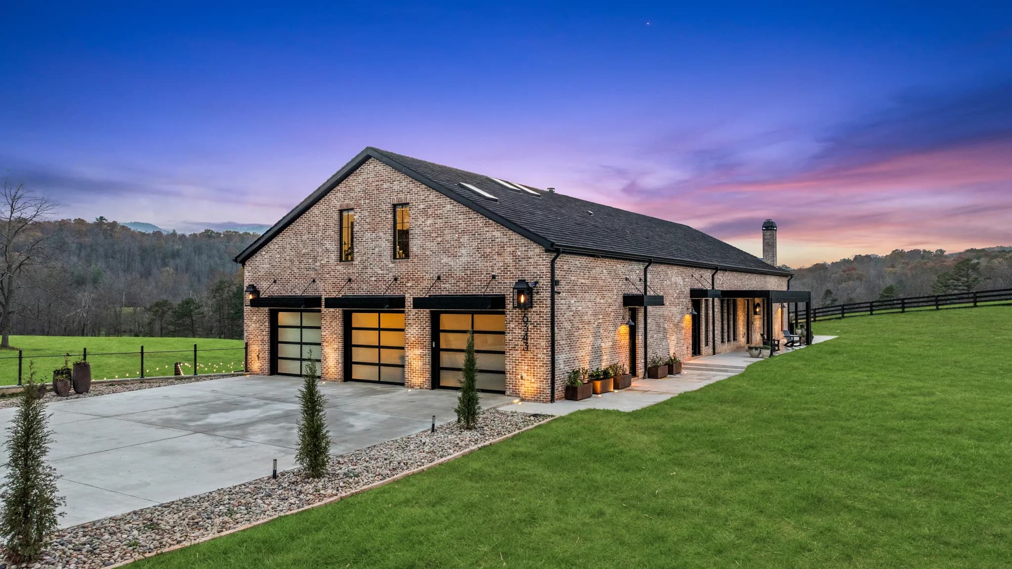 Black K-NOPY cantilevered awning over garage entries at dusk