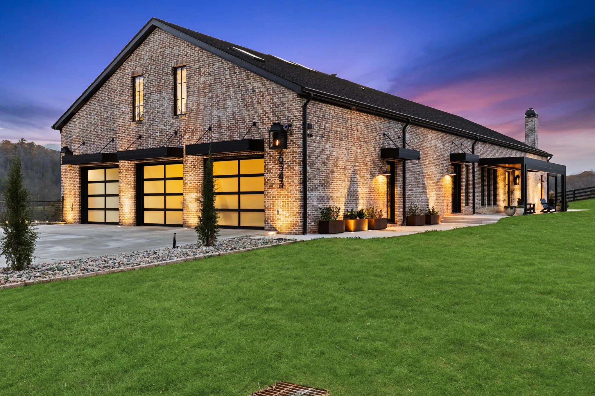 K-NOPY cantilevered awnings over a modern barn-style home at dusk