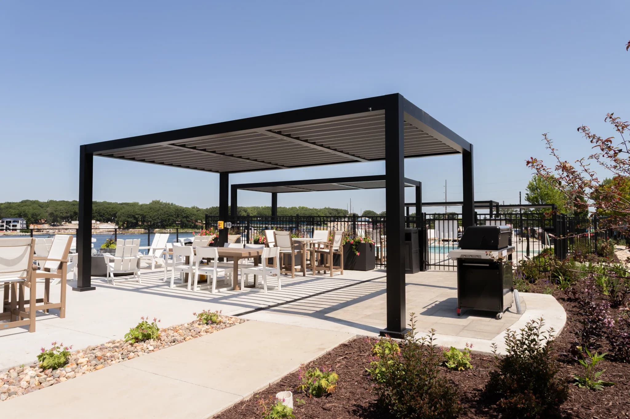 Black R-BREEZE pergola over a commercial dining area with pool and grill